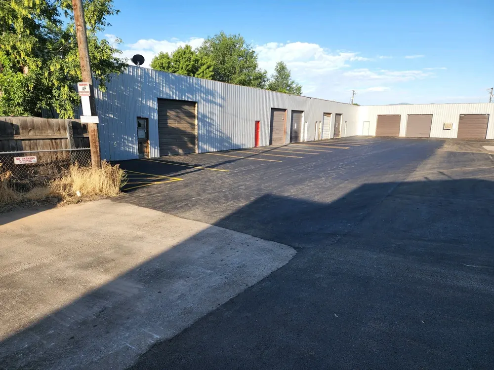 A blue industrial building beside a freshly paved lot