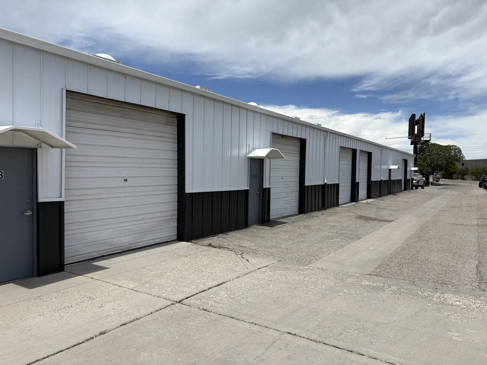 A row of white industrial units with roll up doors